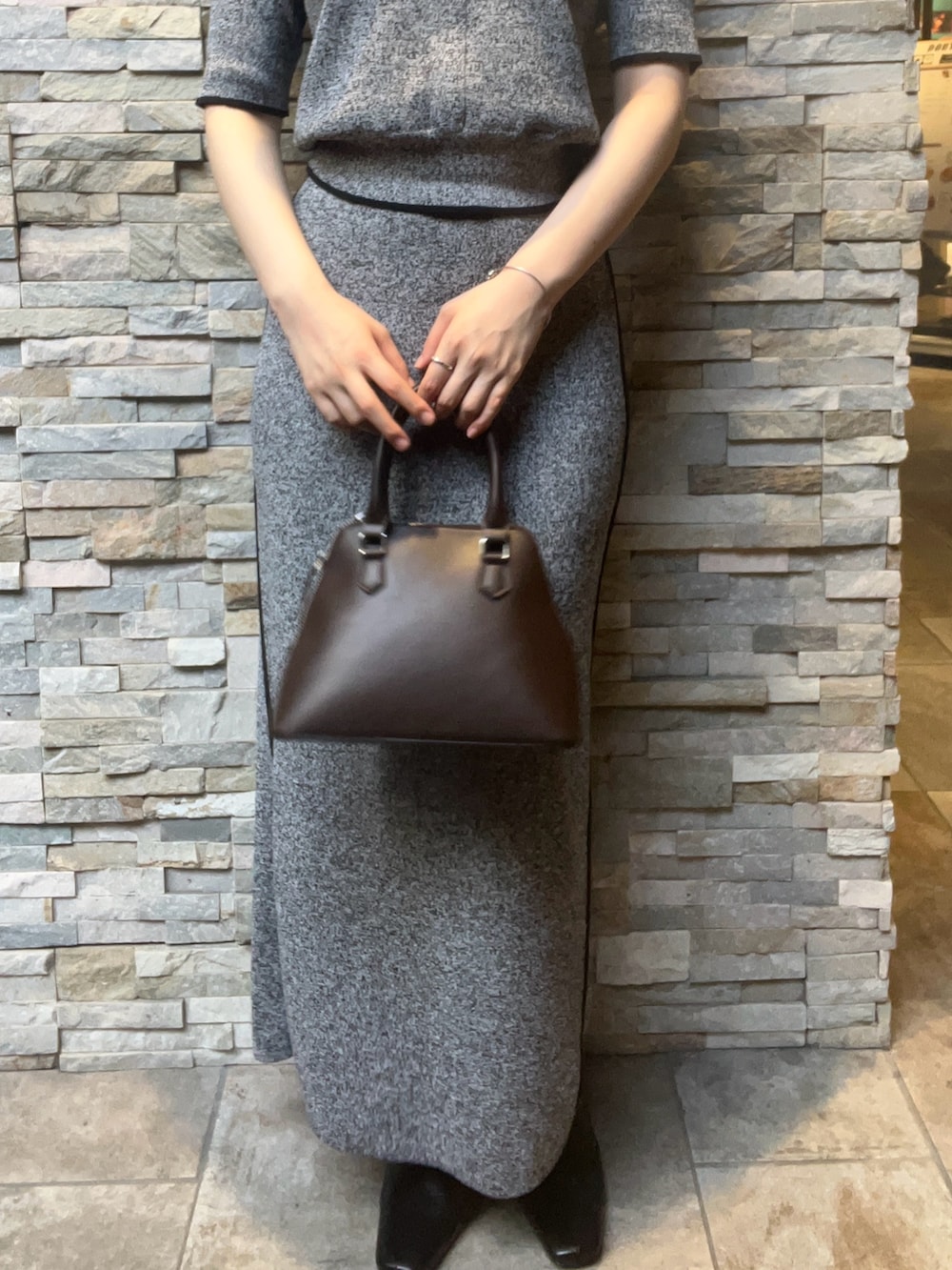 ブラック系のワンピース、ブラック系のブーツ、ブラウン系のボストンバッグを着用したレディースの夏コーディネートの6枚目の写真