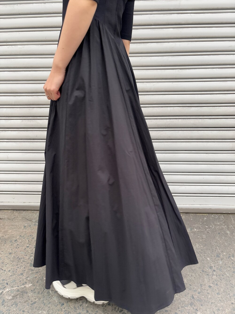 ブラック系のワンピース、ブルー系のテーラードジャケット、グレー系のスニーカーを着用したレディースの冬コーディネートの8枚目の写真