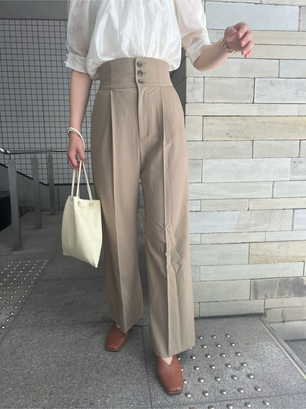 ホワイト系のハンドバッグ、ブラウン系のパンプス、ホワイト系のシャツ/ブラウスを着用したレディースの夏コーディネートの7枚目の写真