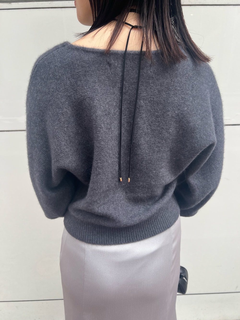 グレー系のニット/セーター、グレー系のカーディガン/ボレロ、ブラック系のスカートを着用したレディースの秋コーディネートの4枚目の写真