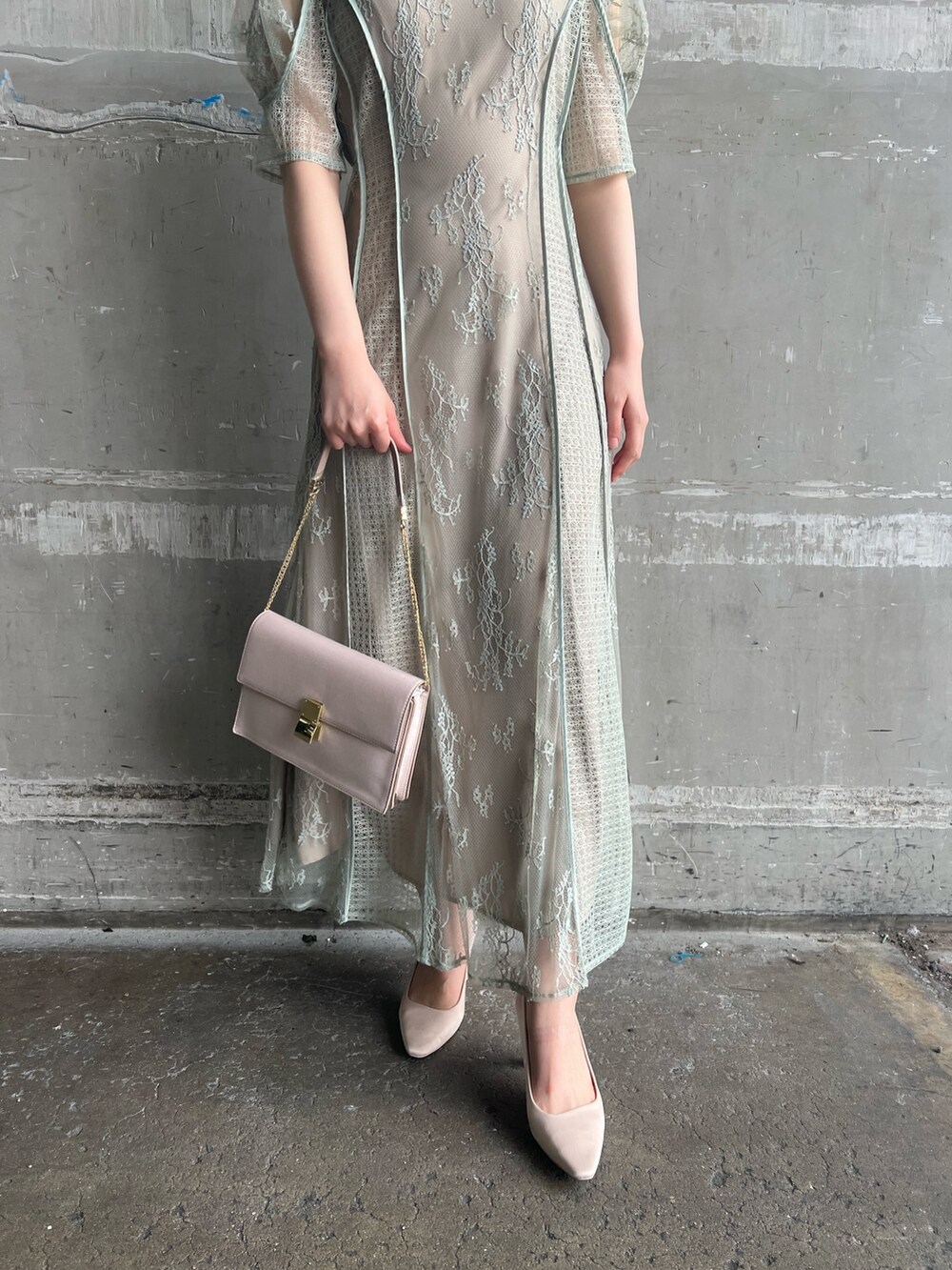 グリーン系のドレス、ベージュ系のパンプス、ベージュ系のクラッチバッグを着用したレディースの春コーディネートの7枚目の写真