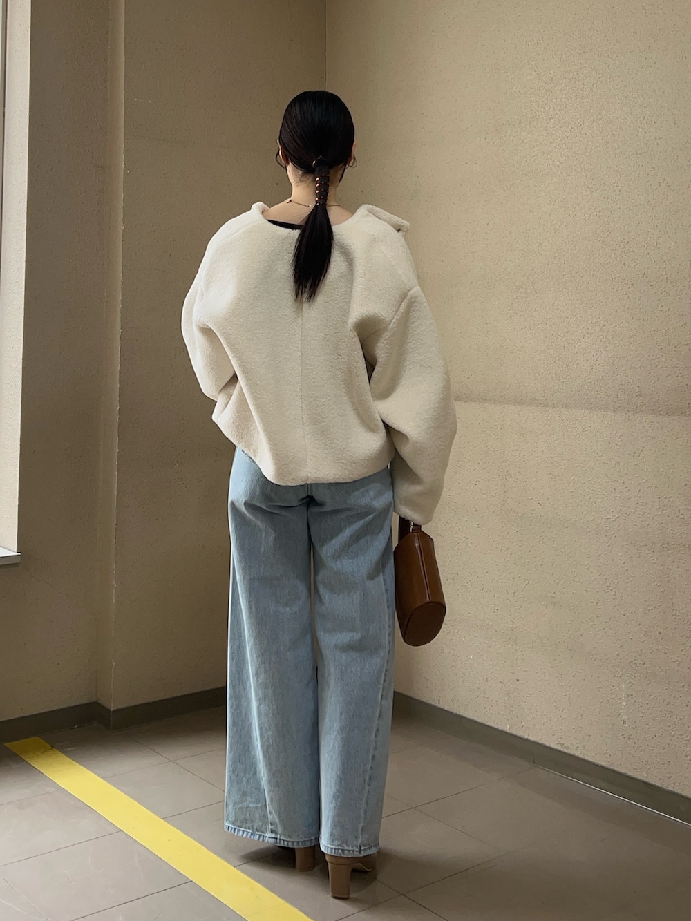 ブルー系のデニムパンツ、ホワイト系のブルゾン、ブラウン系のニット/セーターを着用したレディースの冬コーディネートの3枚目の写真