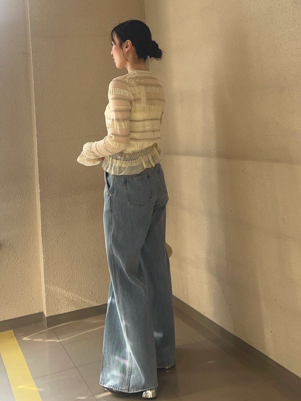 ホワイト系のニット/セーター、ブルー系のデニムパンツを着用したレディースの春コーディネートの2枚目の写真