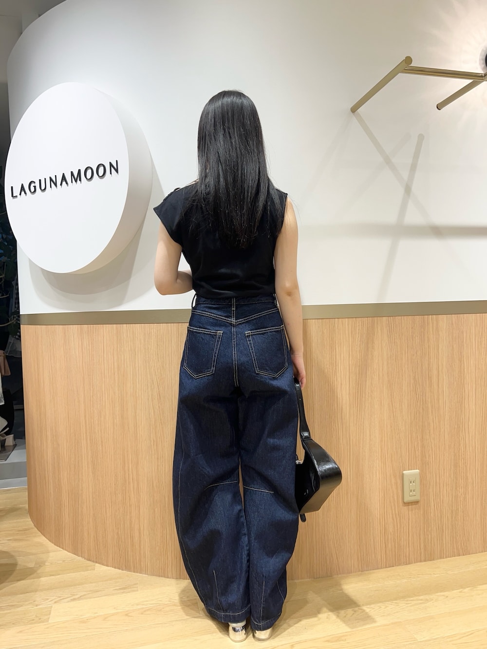 ブルー系のデニムパンツ、グリーン系のパンプス、ブラック系のTシャツ/カットソーを着用したレディースの春コーディネートの5枚目の写真