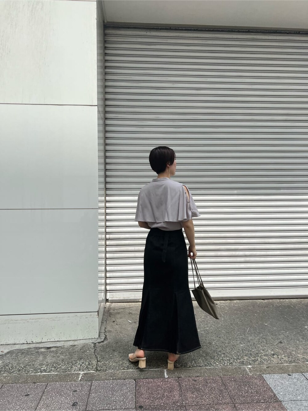 ベージュ系のハンドバッグ、ブラック系のスカート、その他のサンダルを着用したレディースの夏コーディネートの3枚目の写真