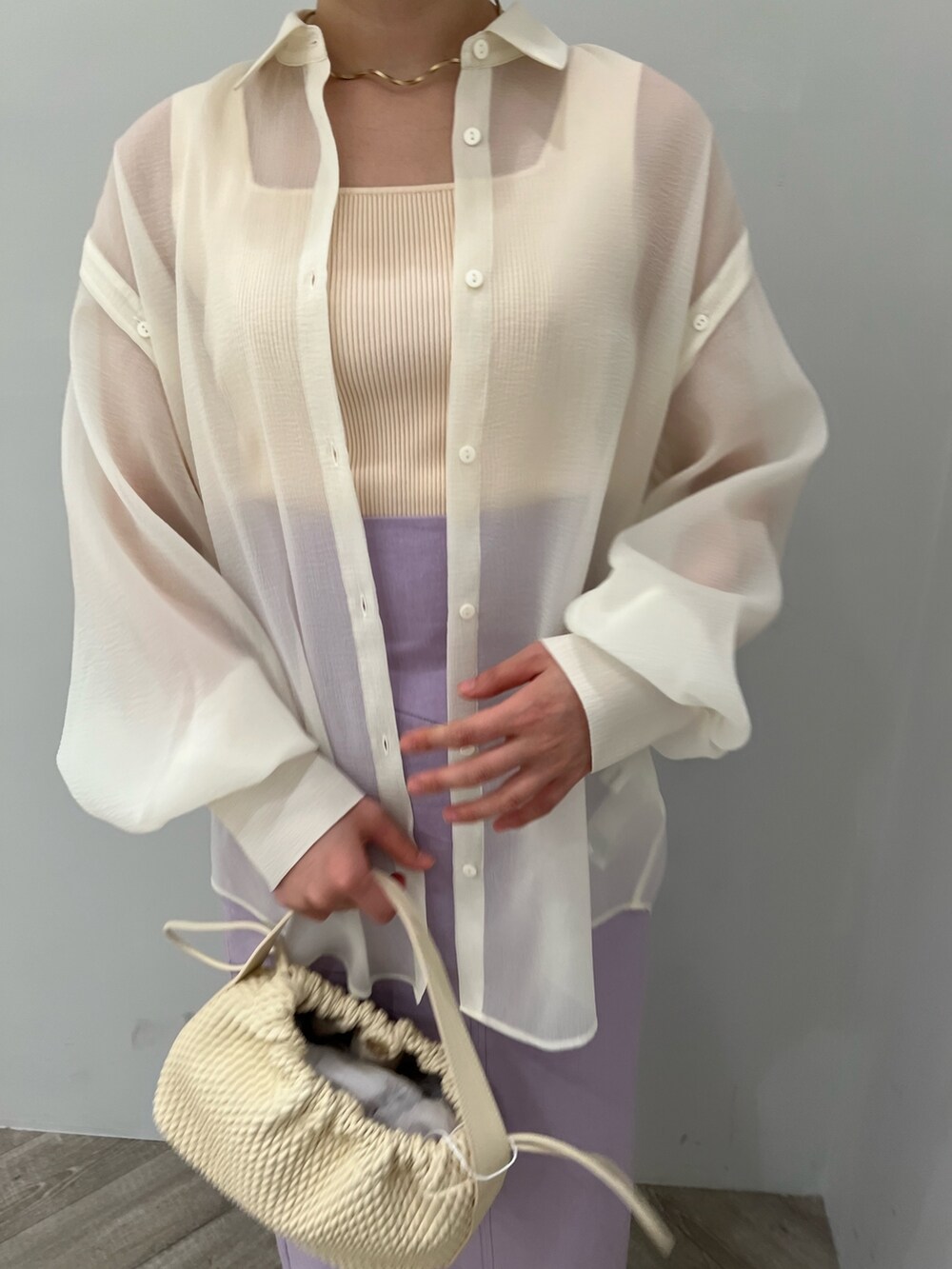 ホワイト系のニット/セーター、ホワイト系のシャツ/ブラウス、ベージュ系のサンダルを着用したレディースの春コーディネートの2枚目の写真