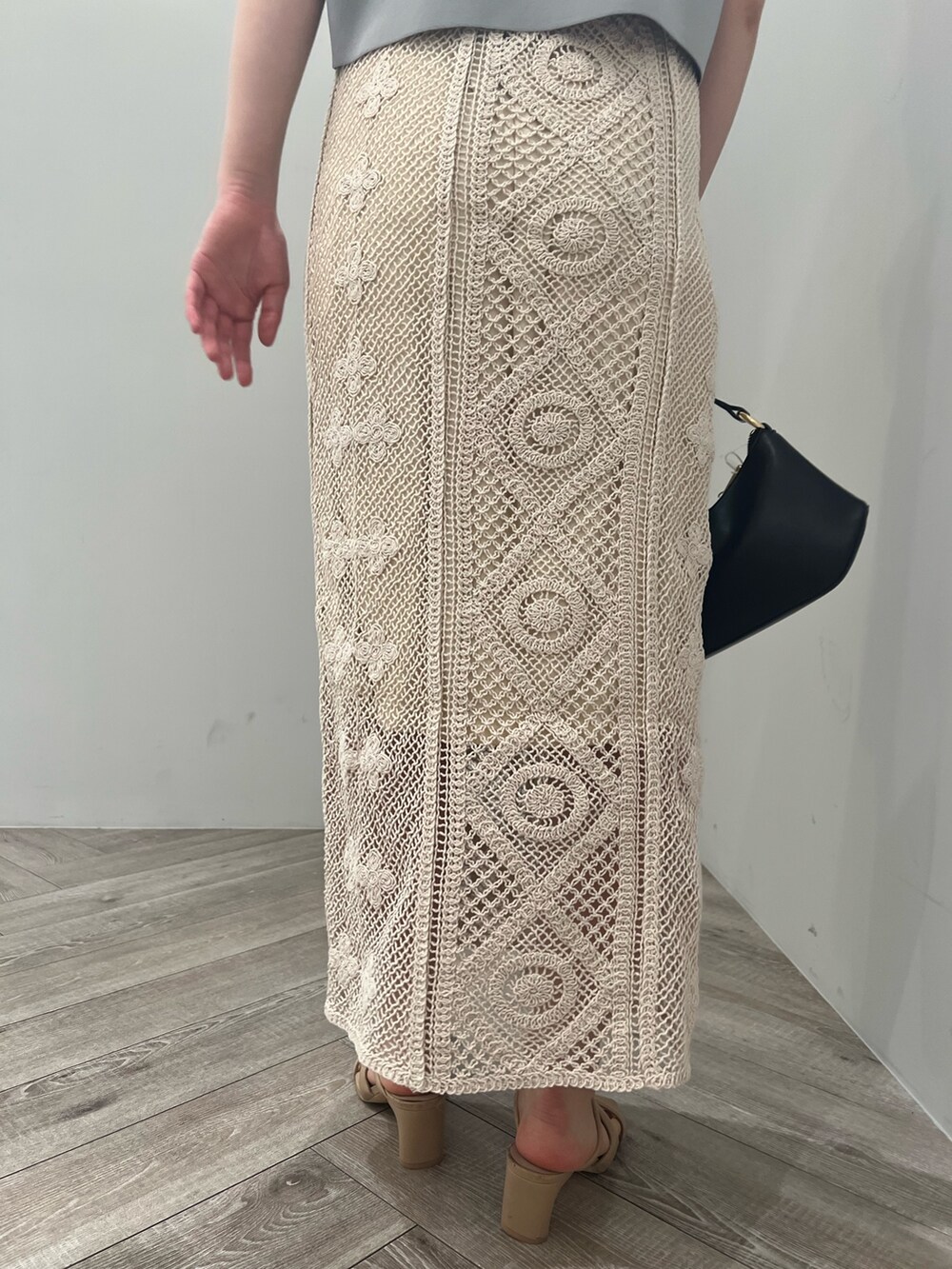 ベージュ系のサンダル、ブラック系のハンドバッグ、ブルー系のニット/セーターを着用したレディースの春コーディネートの8枚目の写真