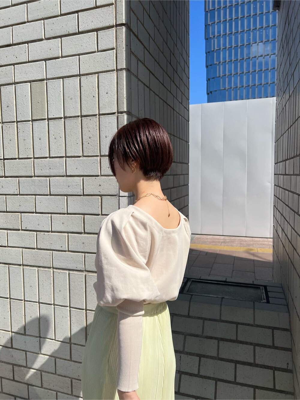 ブルー系のブルゾン、イエロー系のスカート、ベージュ系のスニーカーを着用したレディースの春コーディネートの6枚目の写真