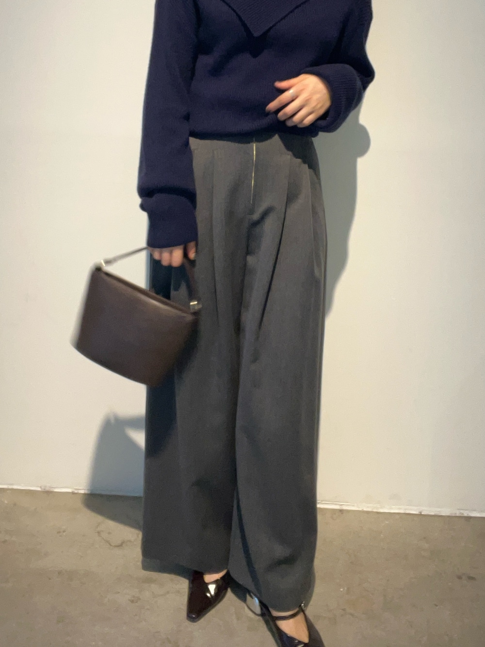 イエロー系のハンドバッグ、ブルー系のニット/セーター、ブラウン系のパンプスを着用したレディースの秋コーディネートの6枚目の写真