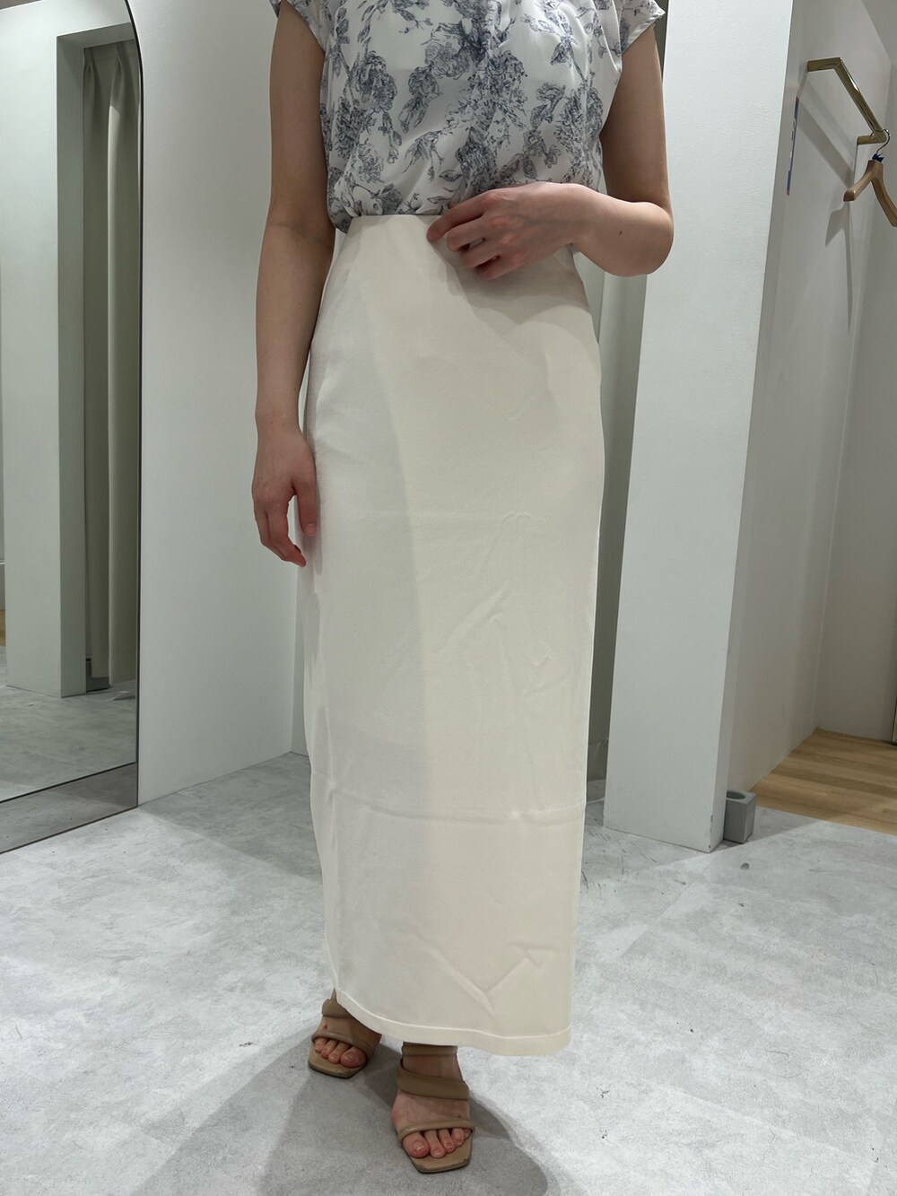 ホワイト系のスカート、ベージュ系のサンダル、ブルー系のシャツ/ブラウスを着用したレディースの春コーディネートの6枚目の写真