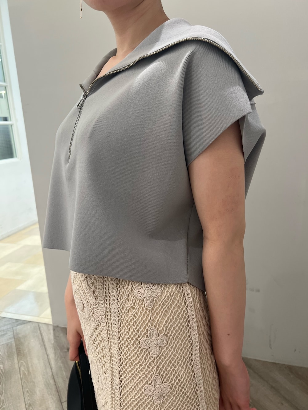 ベージュ系のサンダル、ブラック系のハンドバッグ、ブルー系のニット/セーターを着用したレディースの春コーディネートの4枚目の写真