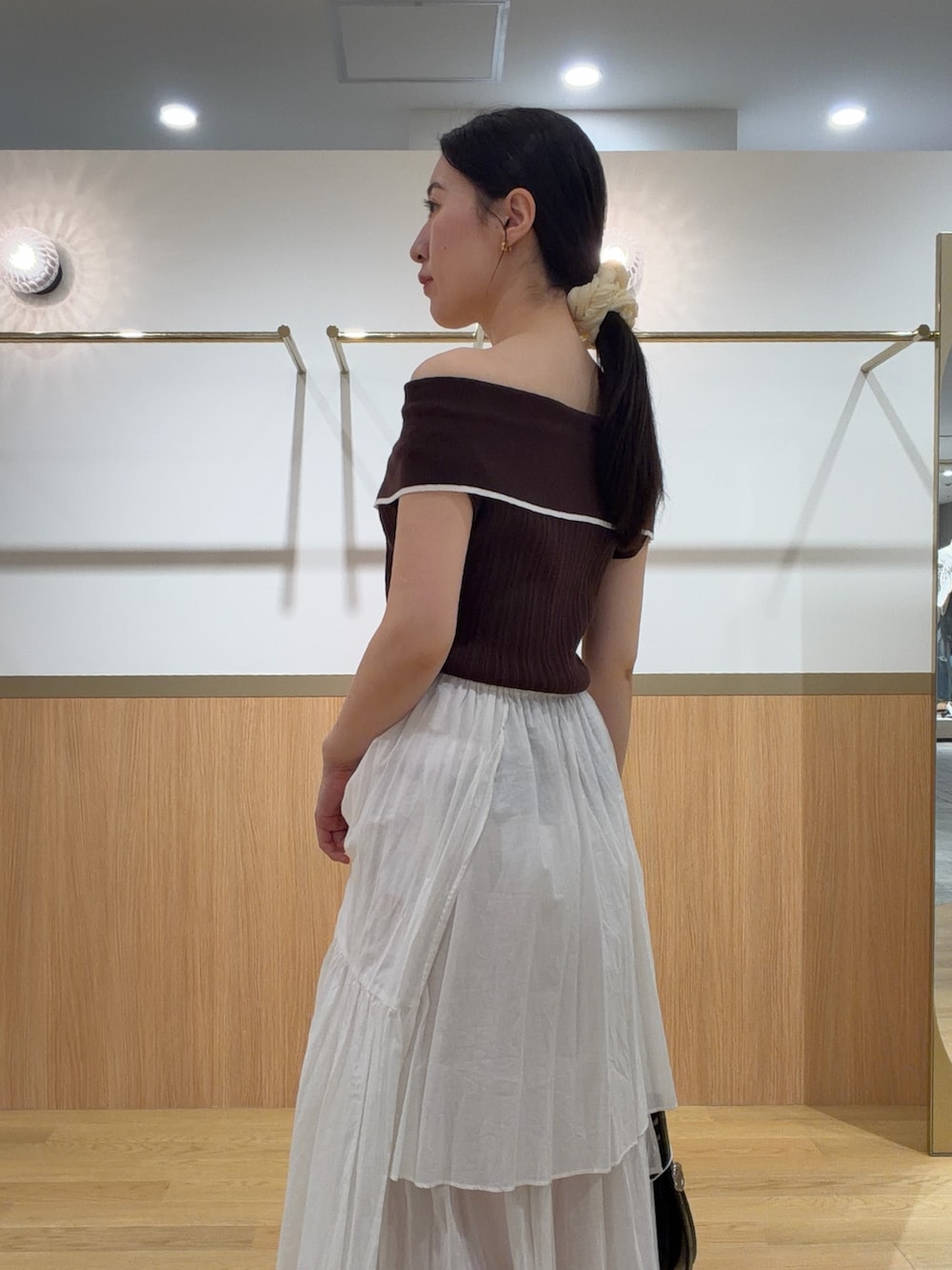ブラウン系のニット/セーター、ブラウン系のサンダル、ホワイト系のスカートを着用したレディースの夏コーディネートの5枚目の写真