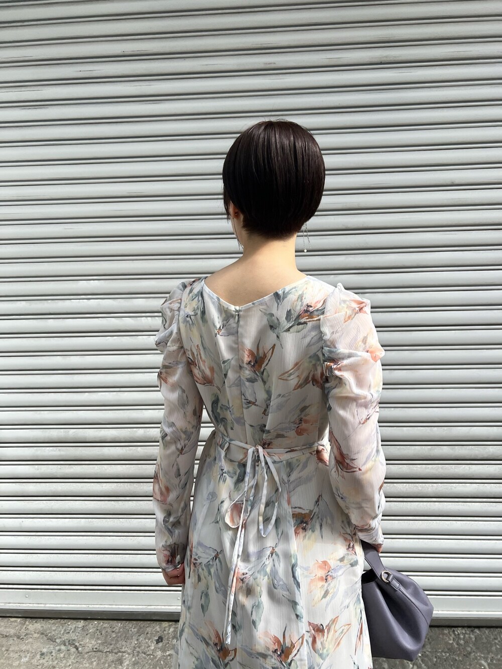 レッド系のブーツ、パープル系のハンドバッグ、ホワイト系のカーディガン/ボレロを着用したレディースの冬コーディネートの9枚目の写真