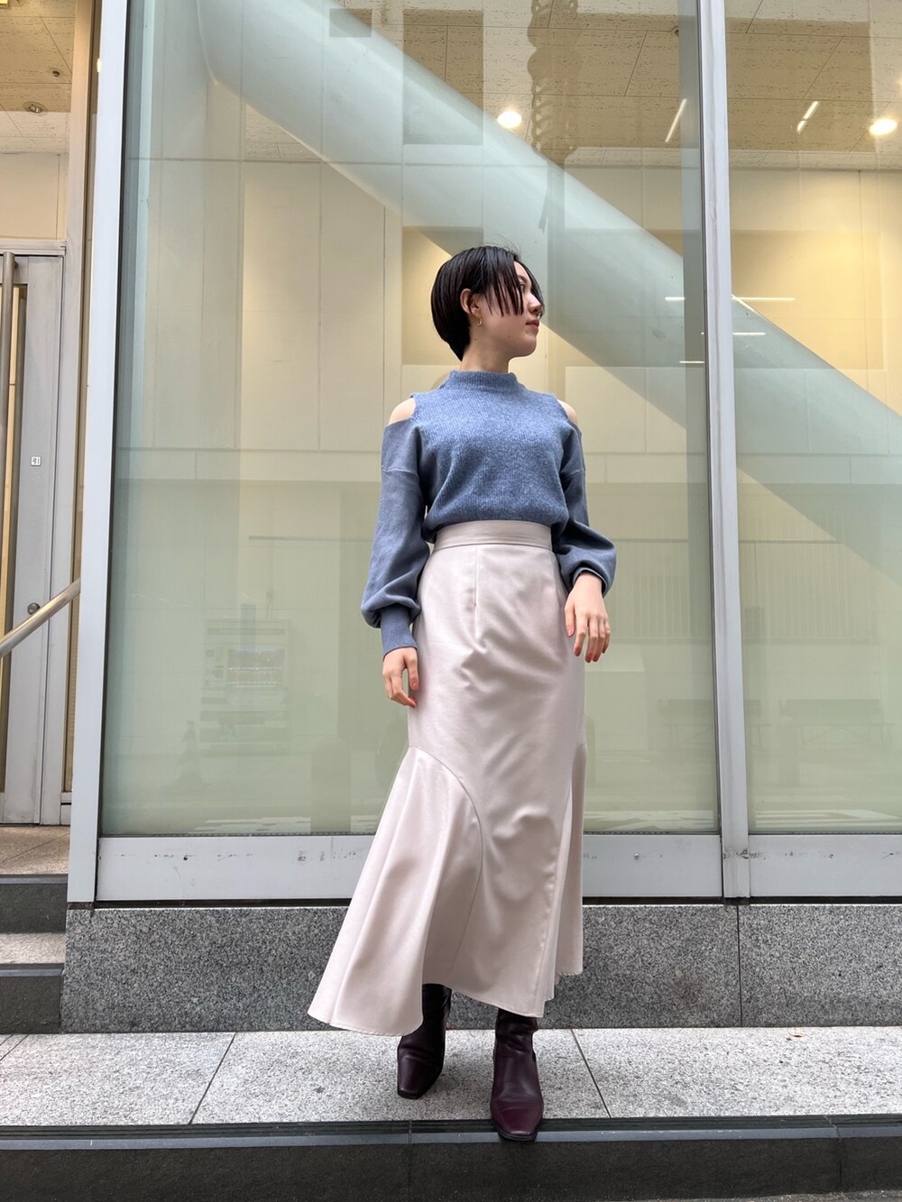 レッド系のブーツ、グレー系のスカート、ブラック系のその他アウターを着用したレディースの冬コーディネートの6枚目の写真