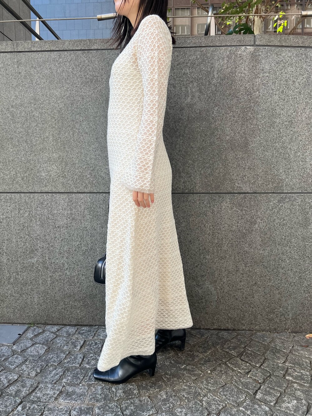 ホワイト系のブルゾン、ホワイト系のワンピース、ブラック系のブーツを着用したレディースの秋コーディネートの9枚目の写真