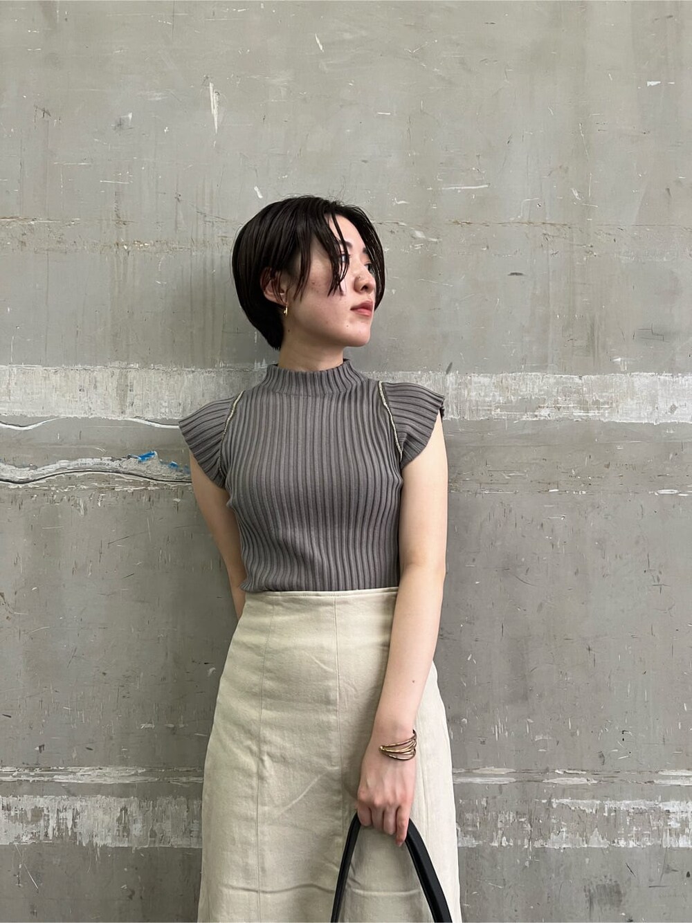 ブラウン系のパンプス、ベージュ系のデニムジャケット、ベージュ系のスカートを着用したレディースの夏コーディネートの5枚目の写真