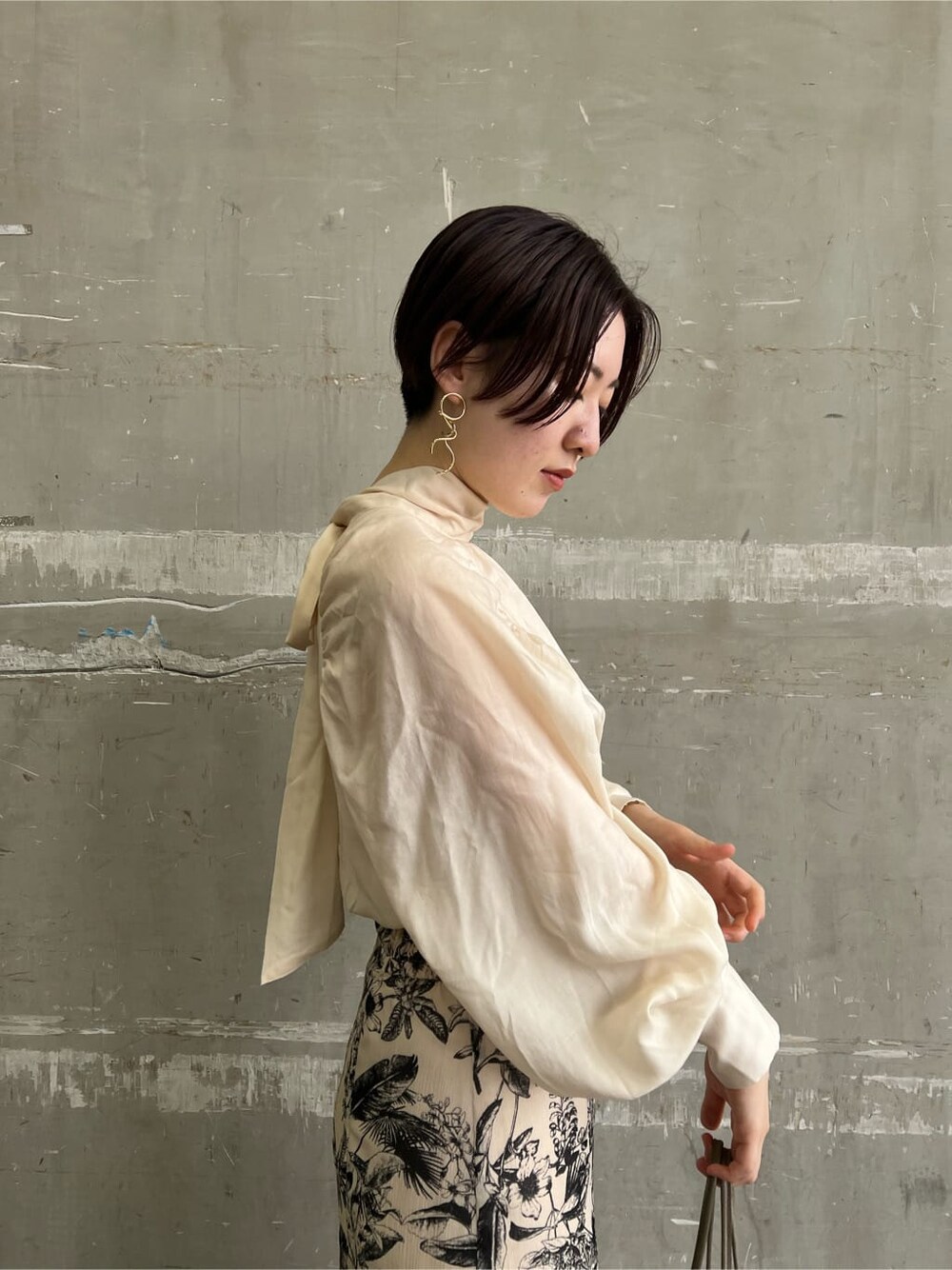 ベージュ系のハンドバッグ、ベージュ系のスカート、ブラウン系のシャツ/ブラウスを着用したレディースの夏コーディネートの5枚目の写真