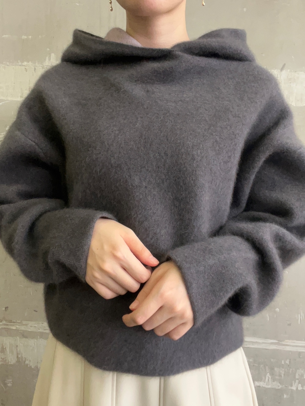 ベージュ系のブーツ、グレー系のパーカー、ホワイト系のスカートを着用したレディースの秋コーディネートの4枚目の写真