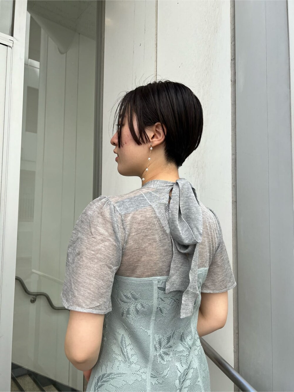 ゴールド系のクラッチバッグ、ゴールド系のパンプス、ブルー系のドレスを着用したレディースの秋コーディネートの9枚目の写真