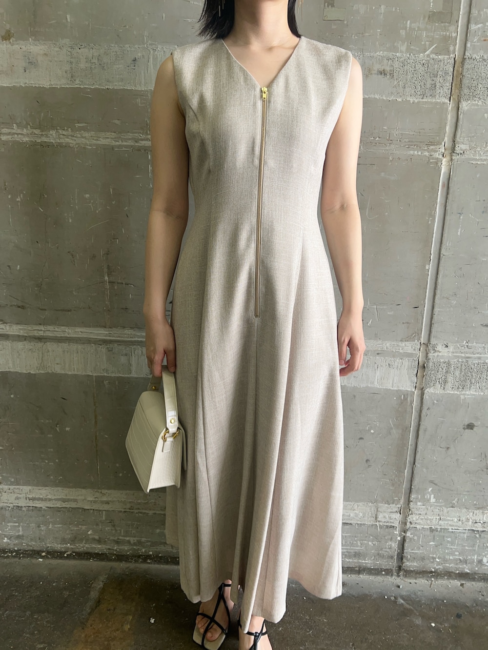 ブラック系のサンダル、ホワイト系のショルダーバッグ、ベージュ系のワンピースを着用したレディースの夏コーディネートの7枚目の写真