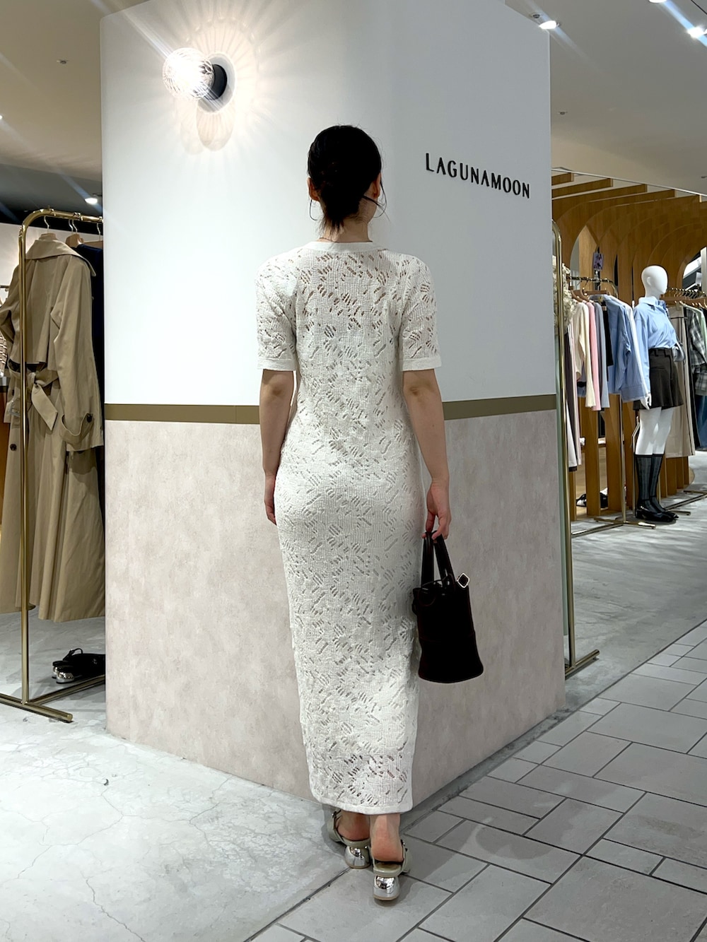 ホワイト系のワンピース、グリーン系のパンプス、ブラウン系のハンドバッグを着用したレディースの春コーディネートの3枚目の写真