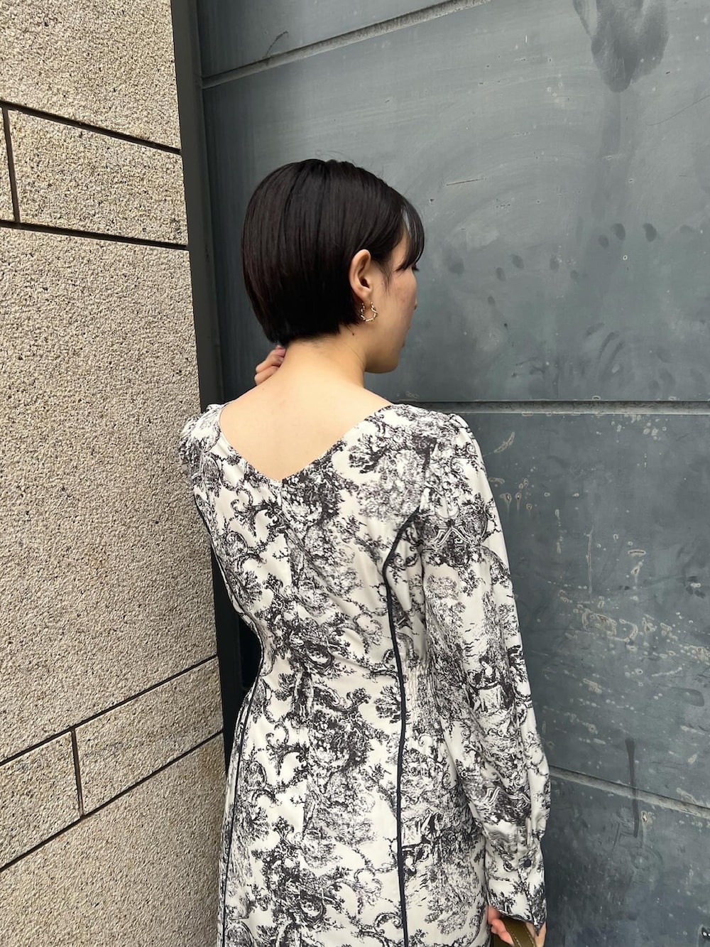 ホワイト系のノーカラーコート、ホワイト系のワンピース、ベージュ系のブーツを着用したレディースの冬コーディネートの7枚目の写真