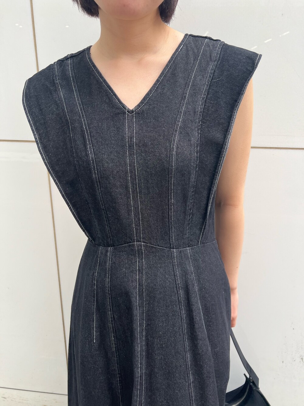 ブラック系のワンピース、ブラック系のサンダル、ブラック系のハンドバッグを着用したレディースの春コーディネートの7枚目の写真