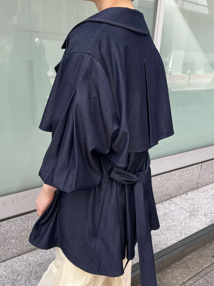 ブルー系のトレンチコート、ブラック系のワンピース、ブラウン系のパンプスを着用したレディースの春コーディネートの3枚目の写真