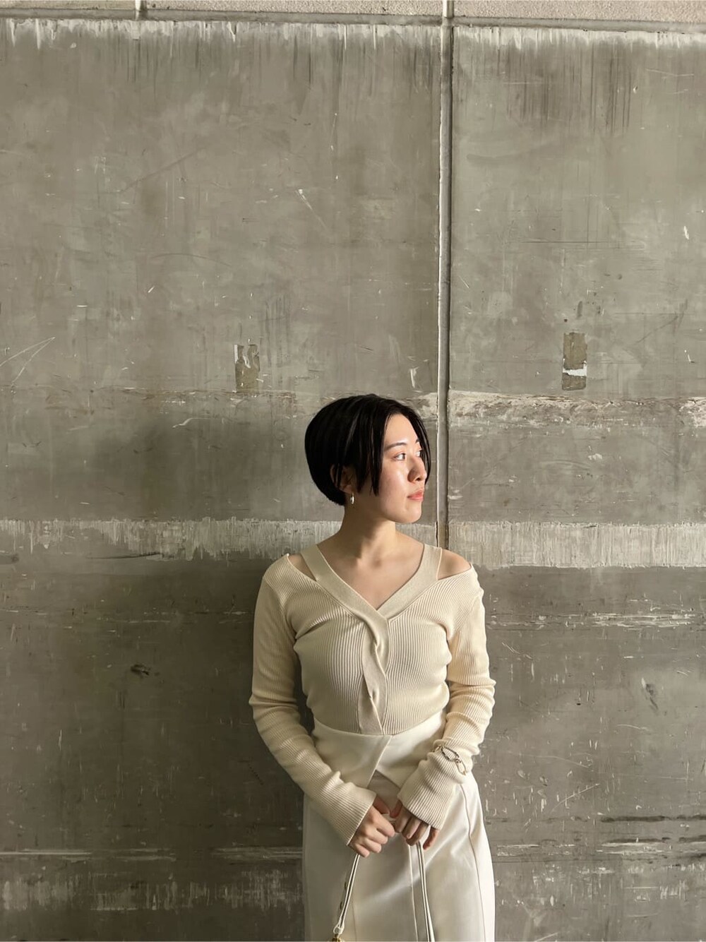 ブラウン系のパンプス、ホワイト系のスカート、ホワイト系のニット/セーターを着用したレディースの夏コーディネートの4枚目の写真