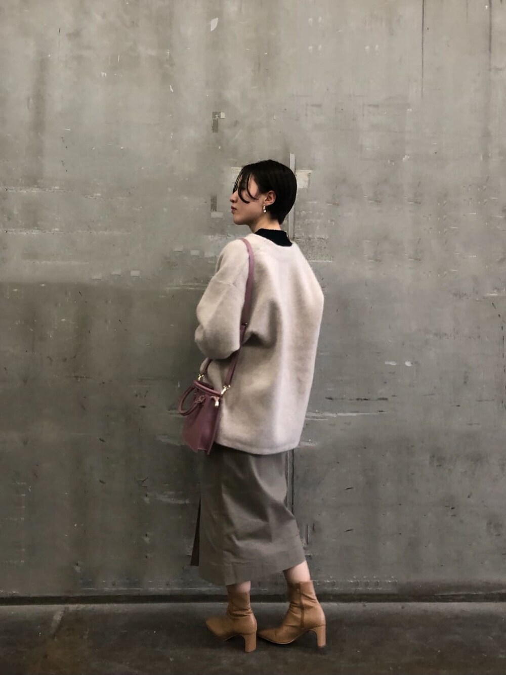 ピンク系のショルダーバッグ、ベージュ系のカーディガン/ボレロ、グレー系のスカートを着用したレディースの秋コーディネートの3枚目の写真