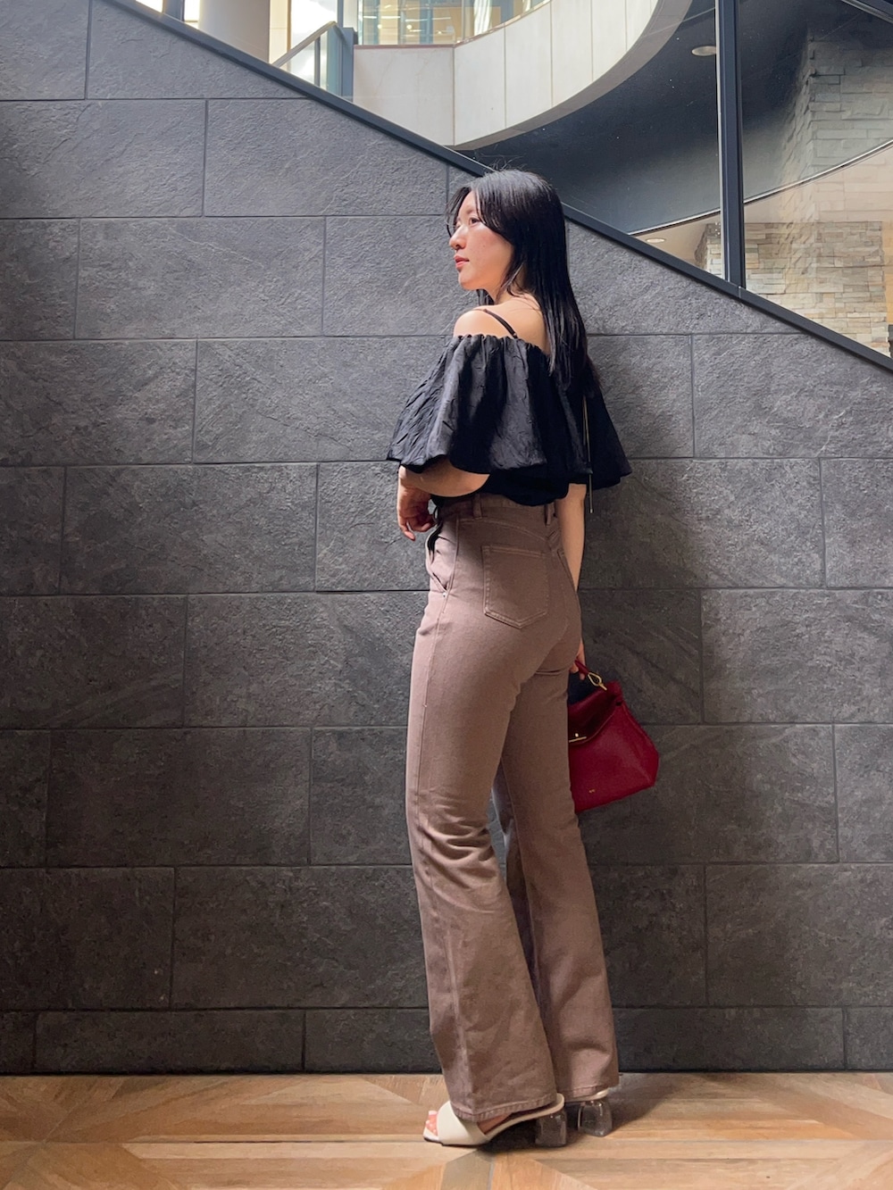 ベージュ系のデニムパンツ、ブラック系のシャツ/ブラウス、ホワイト系のサンダルを着用したレディースの夏コーディネートの2枚目の写真