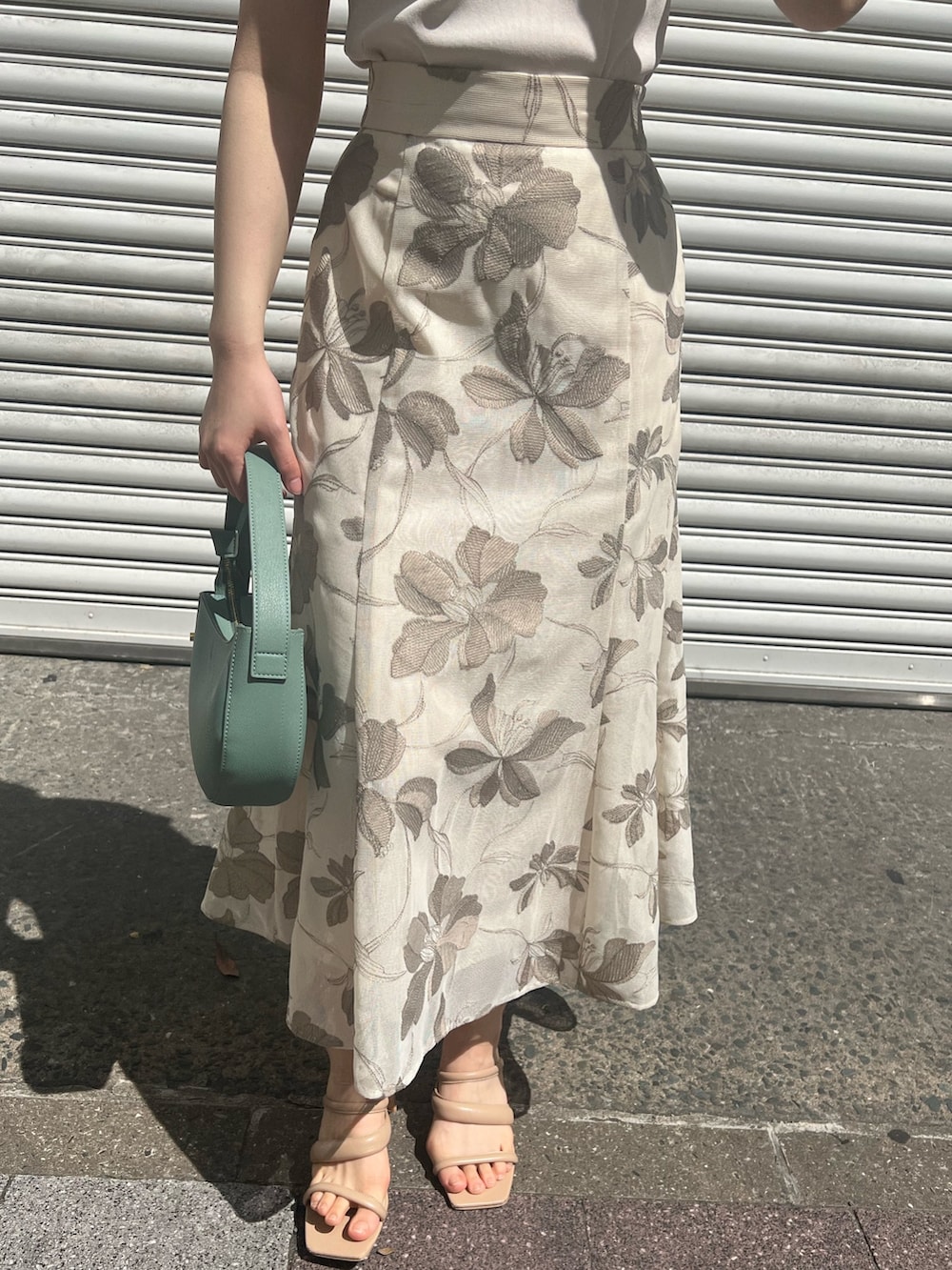 グリーン系のハンドバッグ、ホワイト系のニット/セーター、ベージュ系のサンダルを着用したレディースの春コーディネートの10枚目の写真