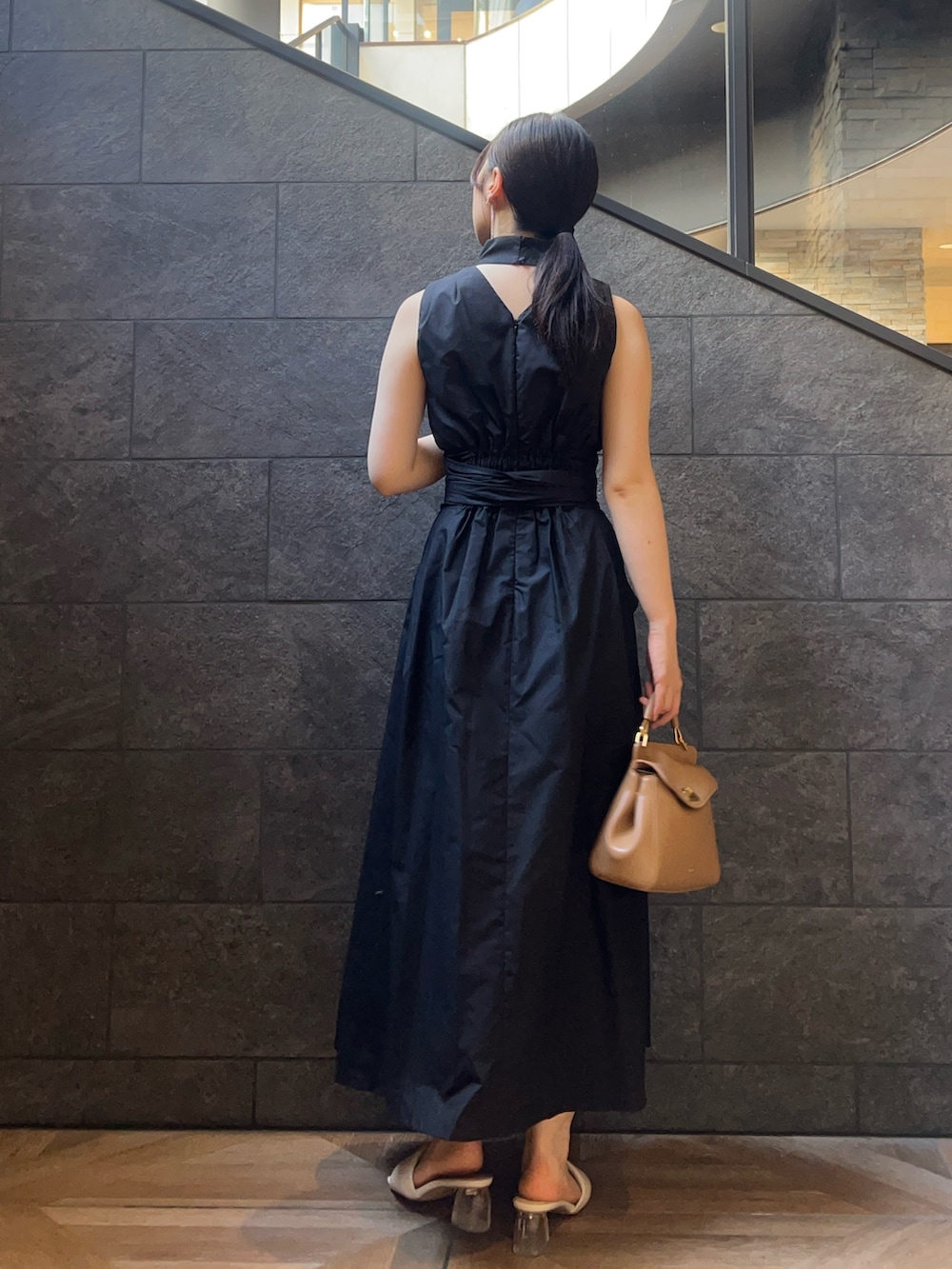 ブラック系のワンピース、ホワイト系のサンダル、レッド系のハンドバッグを着用したレディースの夏コーディネートの3枚目の写真