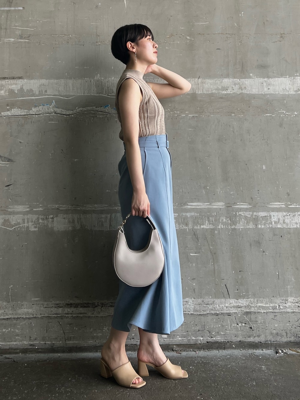 ベージュ系のニット/セーター、ブルー系のスカート、ベージュ系のサンダルを着用したレディースの夏コーディネートの3枚目の写真