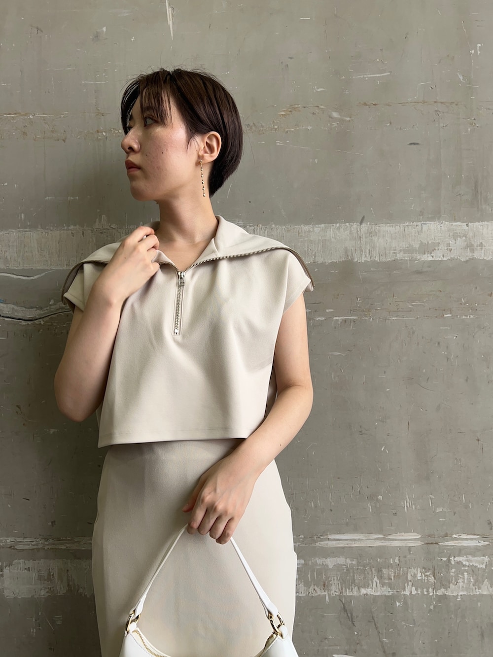 ホワイト系のハンドバッグ、ホワイト系のTシャツ/カットソー、ホワイト系のスカートを着用したレディースの夏コーディネートの4枚目の写真