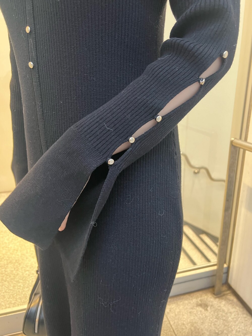 ブラック系のワンピース、ブラウン系のカーディガン/ボレロ、ブラック系のブーツを着用したレディースの冬コーディネートの9枚目の写真
