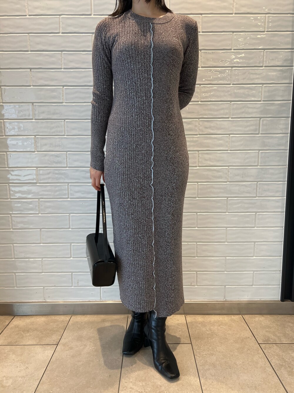 ブラック系のブーツ、ブラック系のショルダーバッグ、ブラック系のワンピースを着用したレディースの秋コーディネートの7枚目の写真