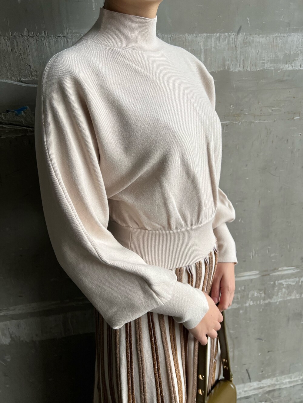 ブラウン系のショルダーバッグ、ベージュ系のブーツ、グレー系のその他アウターを着用したレディースの冬コーディネートの8枚目の写真