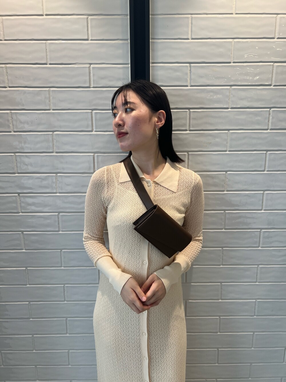 ホワイト系のワンピース、ブラック系のブーツ、ブラウン系のボディバッグ/ウエストポーチを着用したレディースの夏コーディネートの7枚目の写真