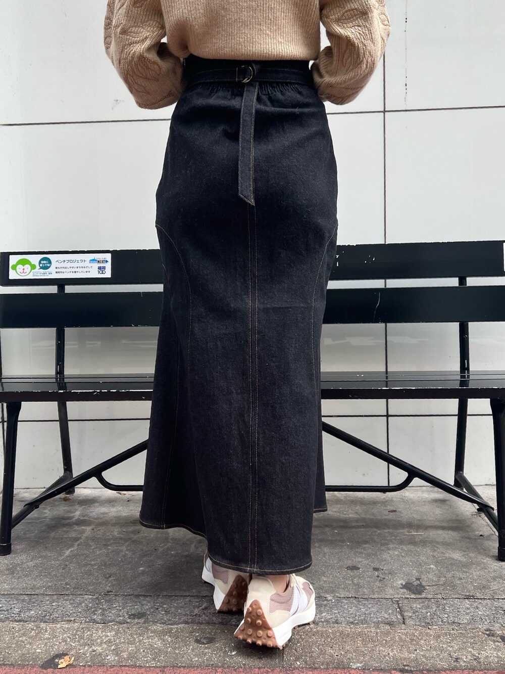 ベージュ系のスニーカー、グリーン系のカーディガン/ボレロ、ブラック系のデニムスカートを着用したレディースの秋コーディネートの10枚目の写真