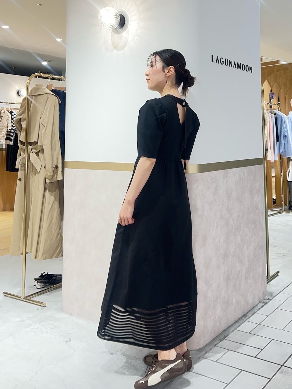 ブラック系のワンピース、ブラウン系のスニーカーを着用したレディースの春コーディネートの2枚目の写真