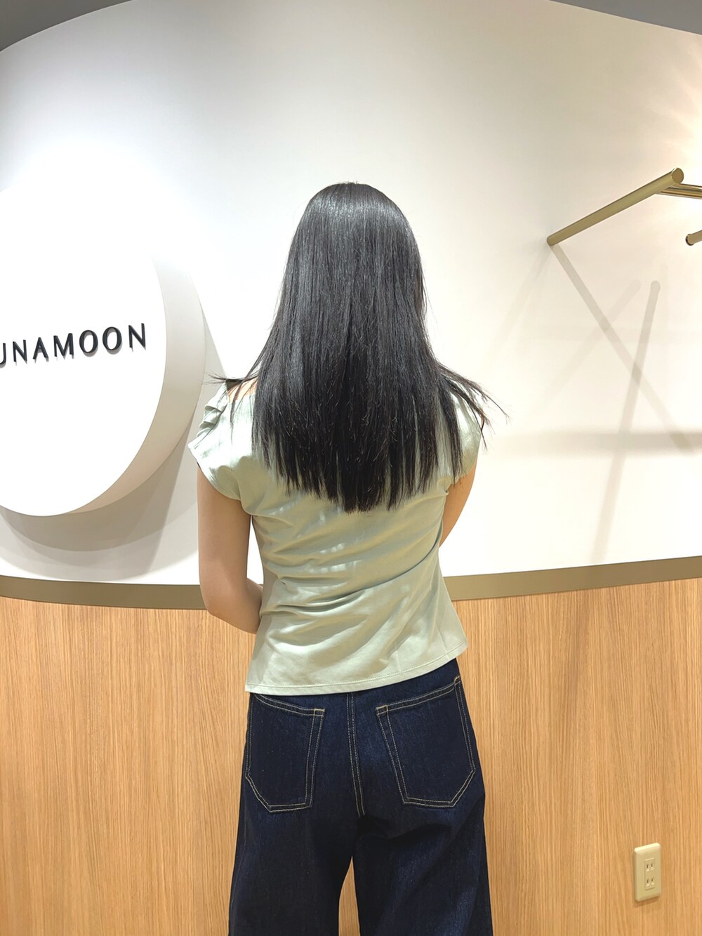 グリーン系のTシャツ/カットソー、ブルー系のデニムパンツ、ブラック系のパンプスを着用したレディースの春コーディネートの5枚目の写真