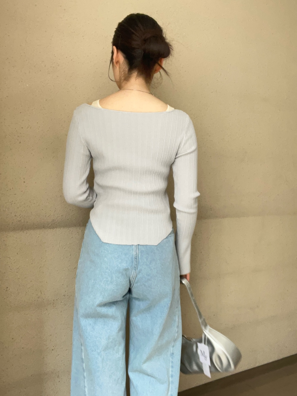 グレー系のニット/セーター、ブルー系のデニムパンツ、ブラック系のパンプスを着用したレディースの春コーディネートの6枚目の写真