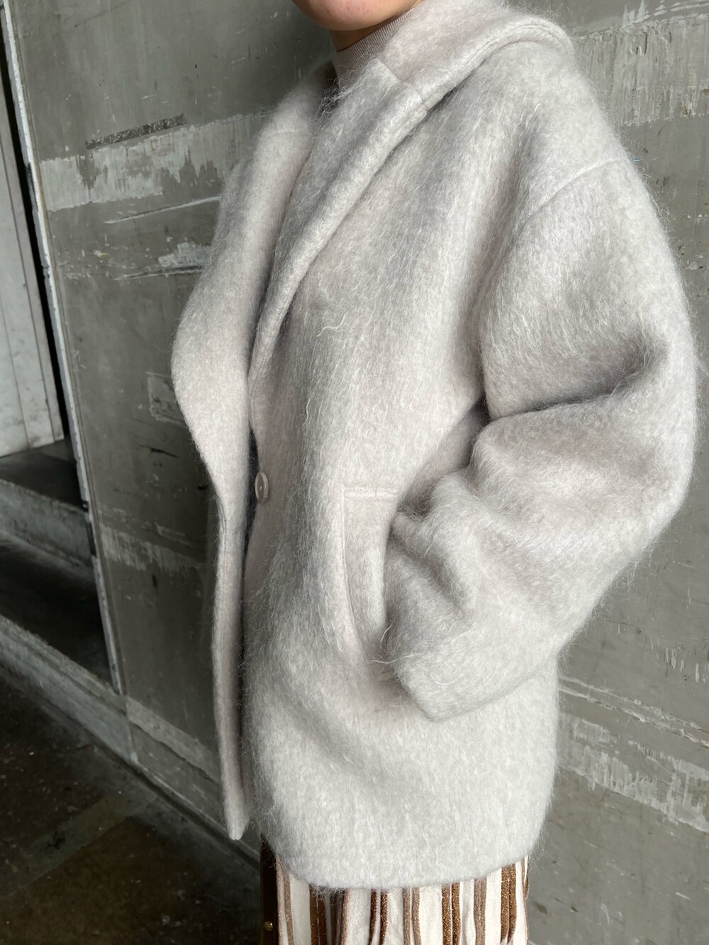 ブラウン系のショルダーバッグ、ベージュ系のブーツ、グレー系のその他アウターを着用したレディースの冬コーディネートの6枚目の写真