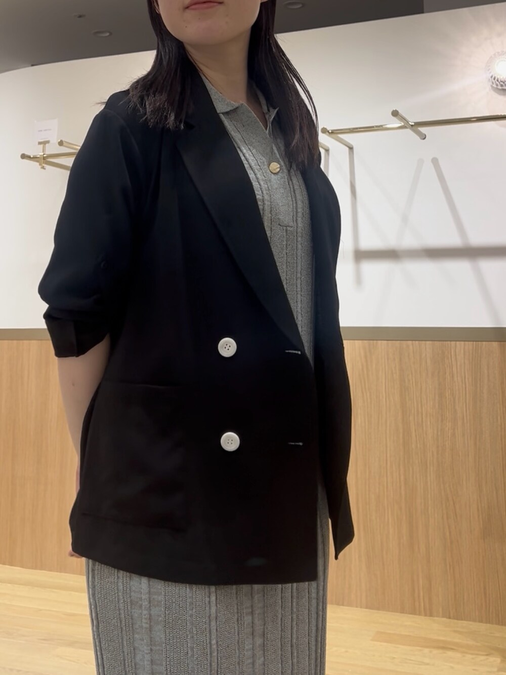 グリーン系のワンピース、ブラック系のテーラードジャケットを着用したレディースの夏コーディネートの4枚目の写真