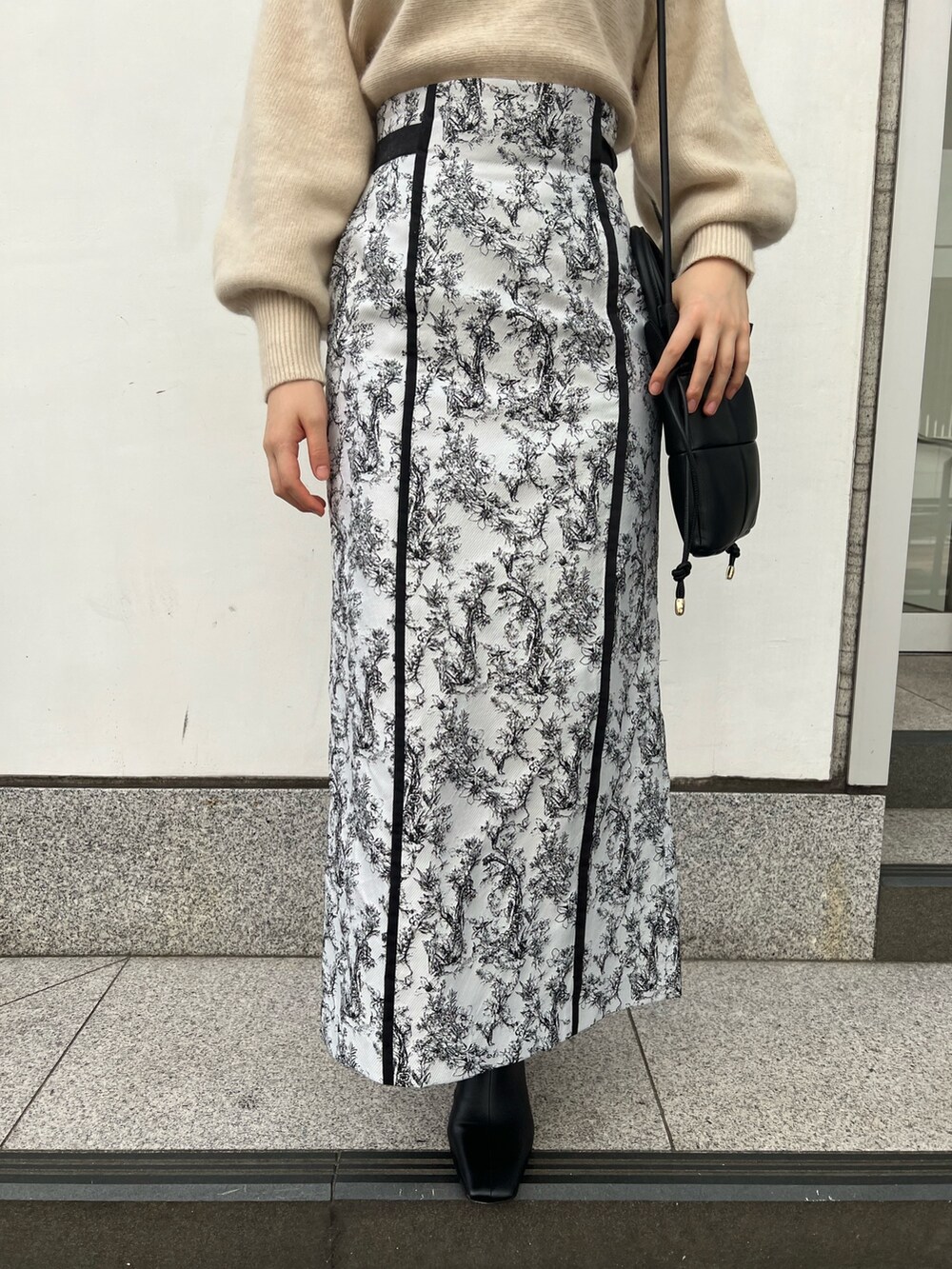 ブラック系のブーツ、ブラック系のスカート、グレー系のカーディガン/ボレロを着用したレディースの秋コーディネートの9枚目の写真