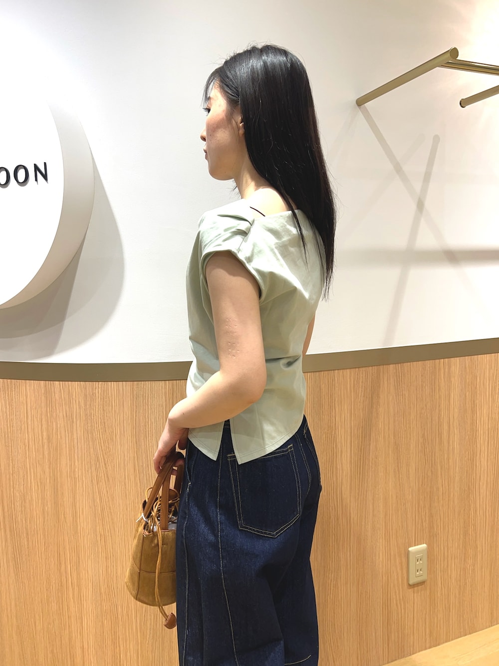 グリーン系のTシャツ/カットソー、ブルー系のデニムパンツ、ブラック系のパンプスを着用したレディースの春コーディネートの4枚目の写真