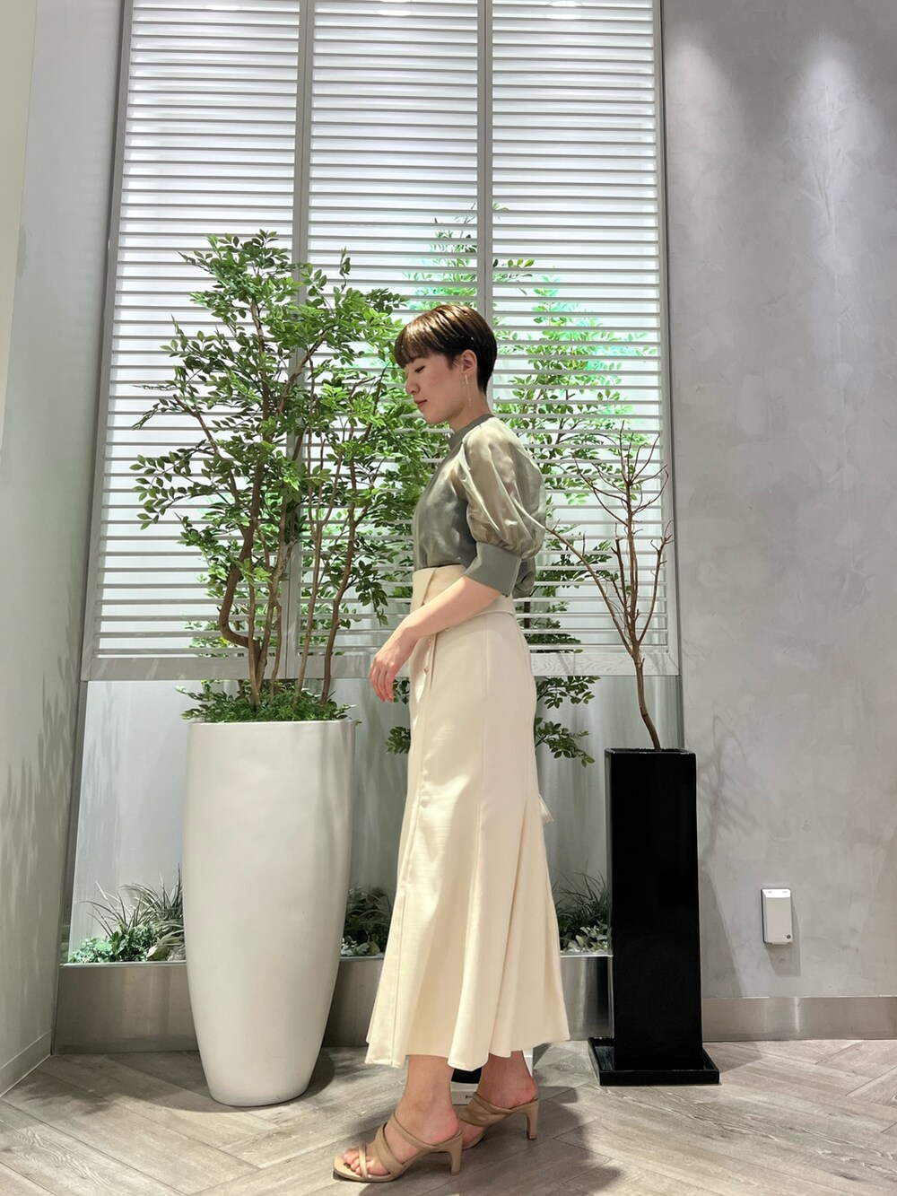 ベージュ系のサンダル、ホワイト系のショルダーバッグ、ホワイト系のスカートを着用したレディースの夏コーディネートの2枚目の写真