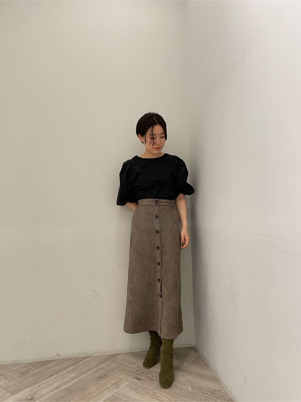 ブラック系のシャツ/ブラウス、グレー系のスカート、ベージュ系のブーツを着用したレディースの秋コーディネートの7枚目の写真