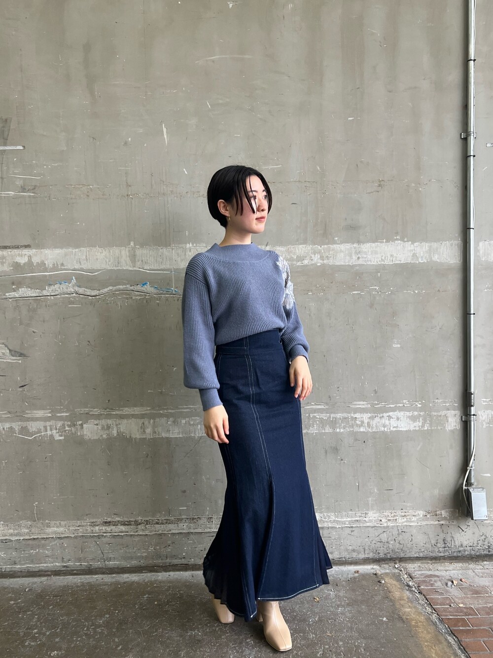 ベージュ系のブーツ、ブルー系のスカート、ホワイト系のダウンジャケット/コートを着用したレディースの冬コーディネートの6枚目の写真